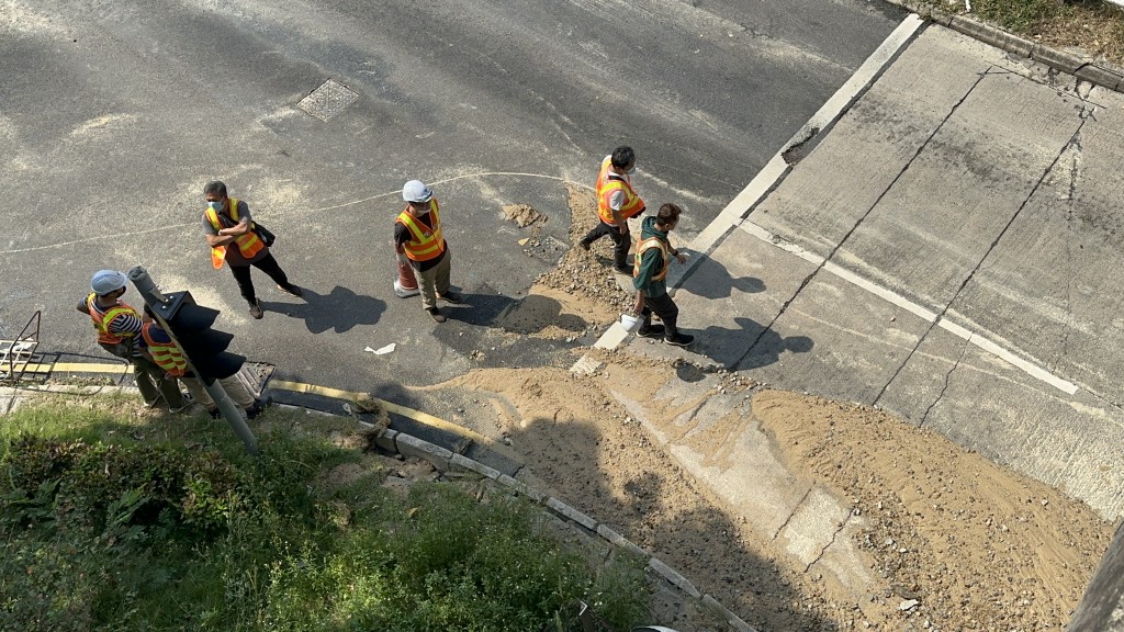沙泥铺满地，工人忙于清理路面。