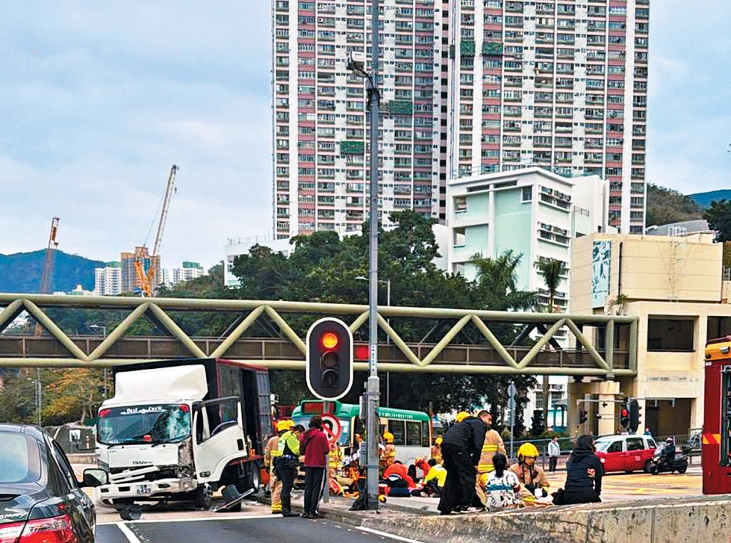 貨車與專線小巴相撞後，傷者坐在石壆上等候救援。
