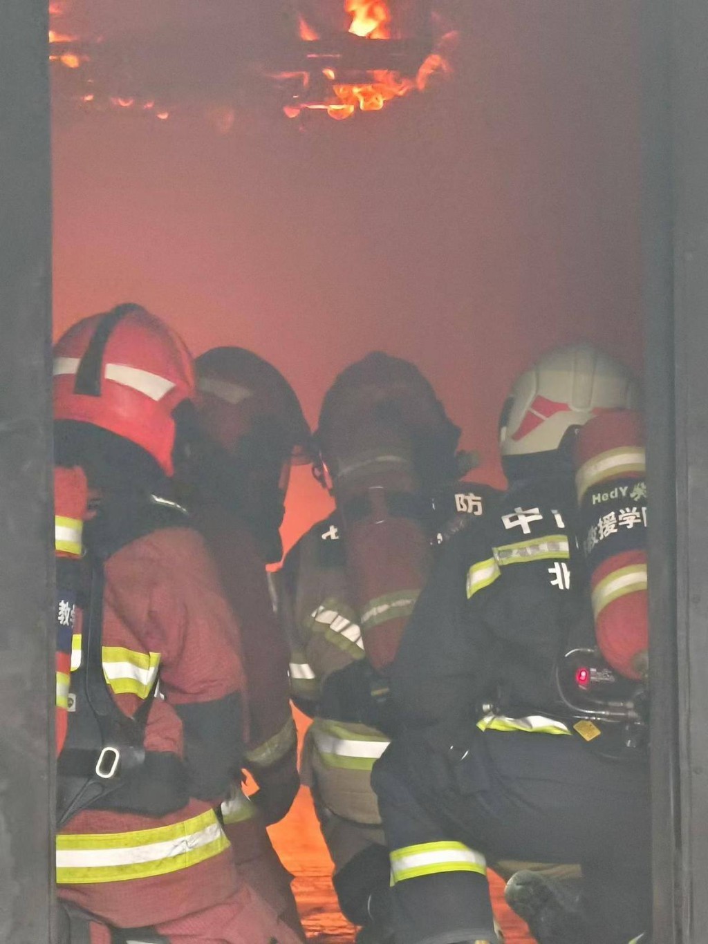 教官帶領學員進入模擬火場實操訓練。