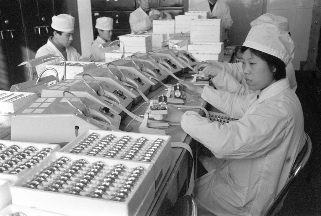 1980年,天津手錶廠裝配車間檢驗組工人測試手錶的精度。新華社 1980年,天津手錶廠裝配車間檢驗組工人測試手錶的精度。新華社
