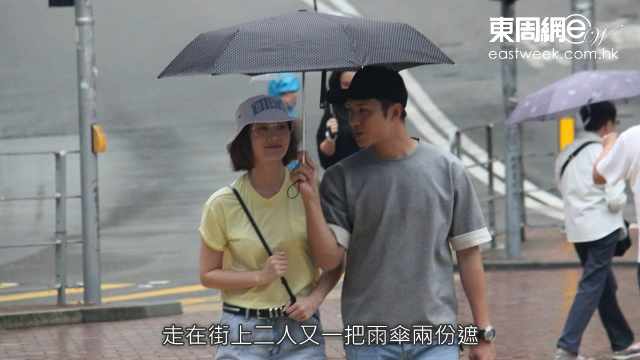 走在街上二人又一把雨伞两份遮，行为举止俨如热恋中的情侣。（东周刊影片截图）