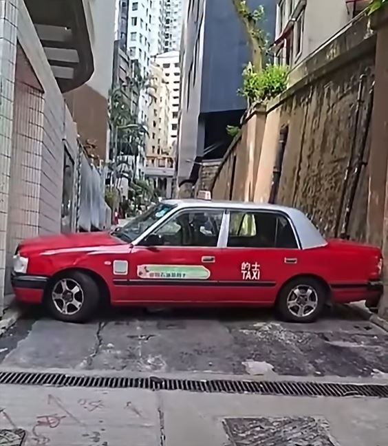 的士「打橫」被困在兩幅石牆之間。fb「車cam L（香港群組）」影片截圖