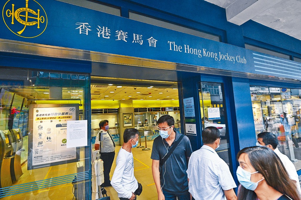 ■有市民到馬會投注站，始知馬會系統故障未能落注，要職員解釋。