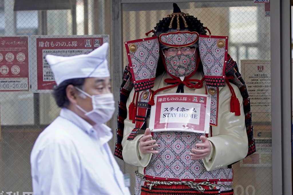 新冠疫情期期間，東京鎌倉一座肯德基爺爺雕像也戴上口罩。 美聯社