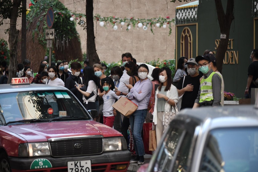 市面人流增加,市民等上的士。