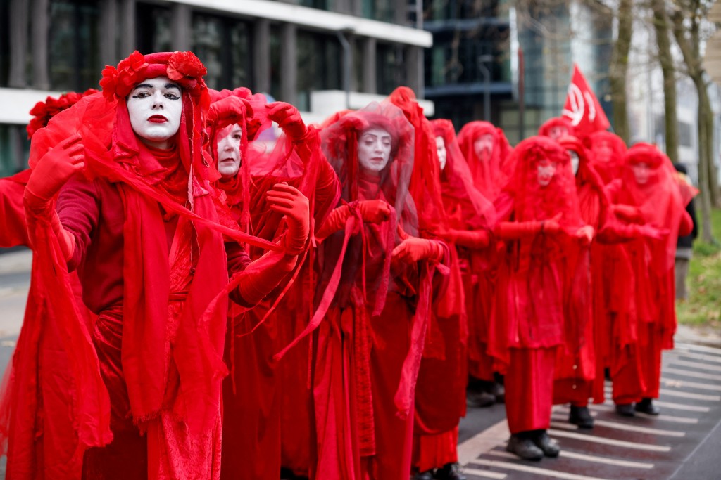 有對抗氣候變化組織一身紅色裝扮參與遊行。路透社