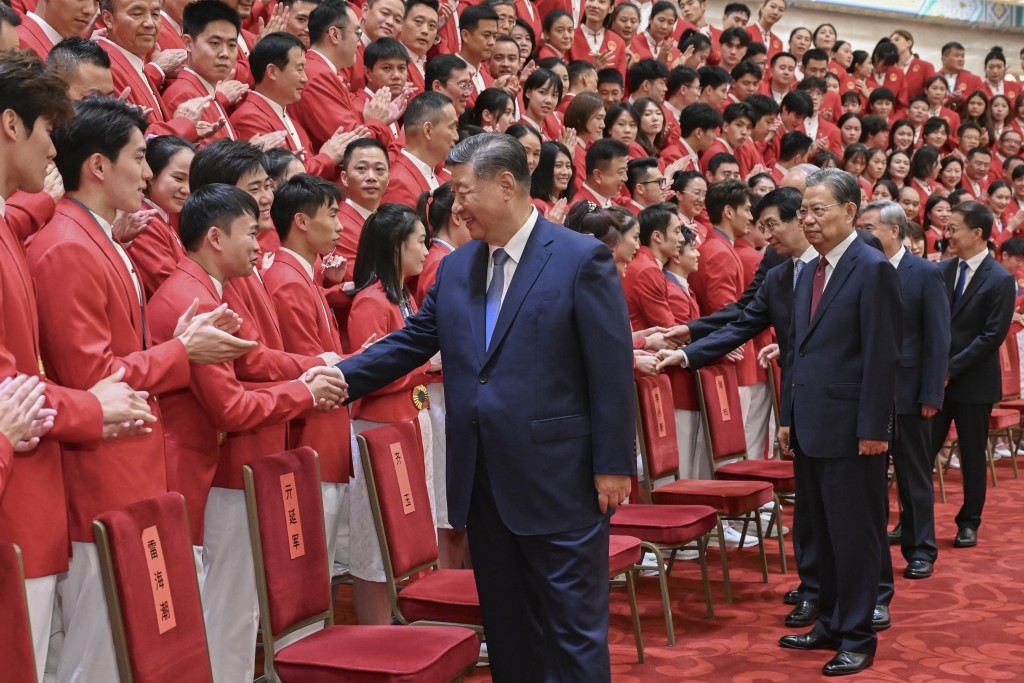 习近平与部份运动员握手。（新华社）