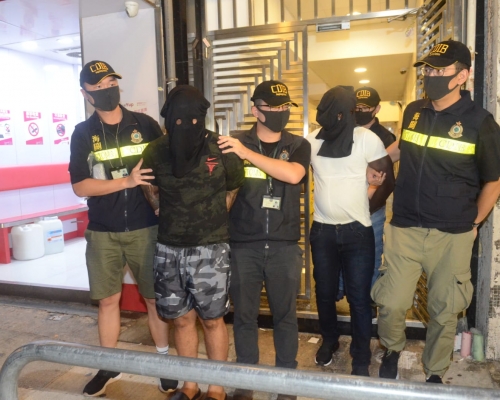 關員押同兩名疑犯到文苑街一住宅單位搜查。