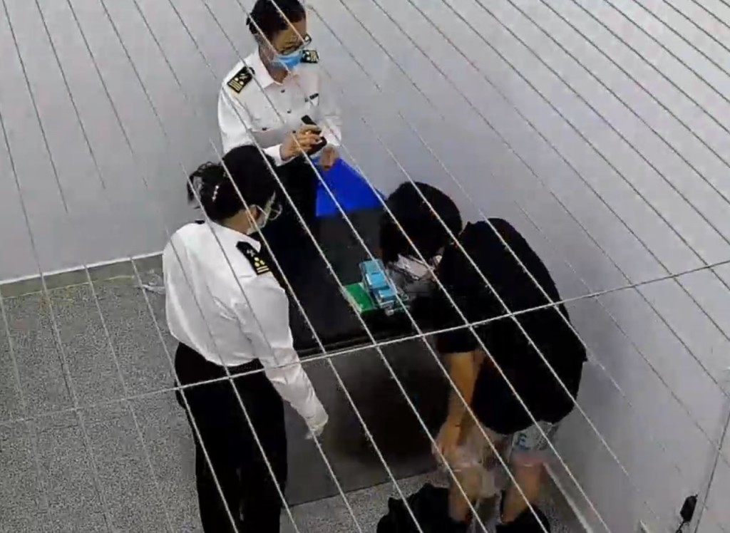 涉事男女在身上纏著共102部舊手機，企圖經拱北入內地。海關發佈
