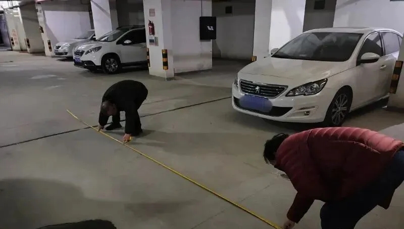 干先生和妻子拿捲尺示意車輛痕跡長度。 干先生和妻子拿捲尺示意車輛痕跡長度。