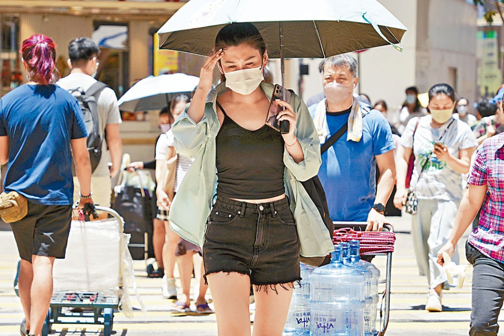 天氣酷熱,市民外出打傘防暑。