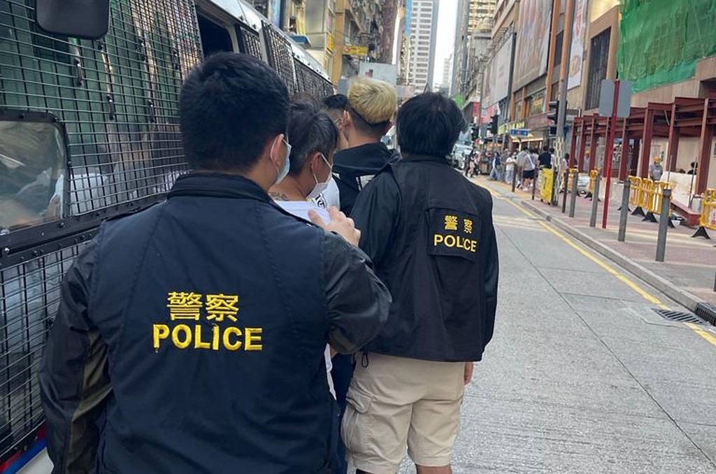 警方將被捕人士帶上警車。