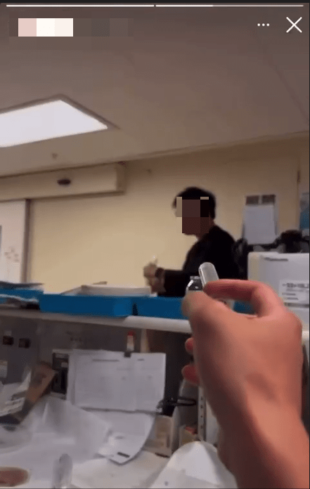 拍攝者以一支類以針筒的物品，向一名黑衣男子射水。網上影片截圖