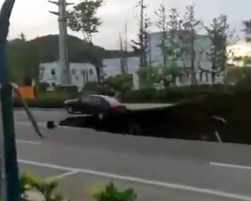 路面出現大面積塌陷，一輛汽車，停在塌陷坑邊緣。（網圖）