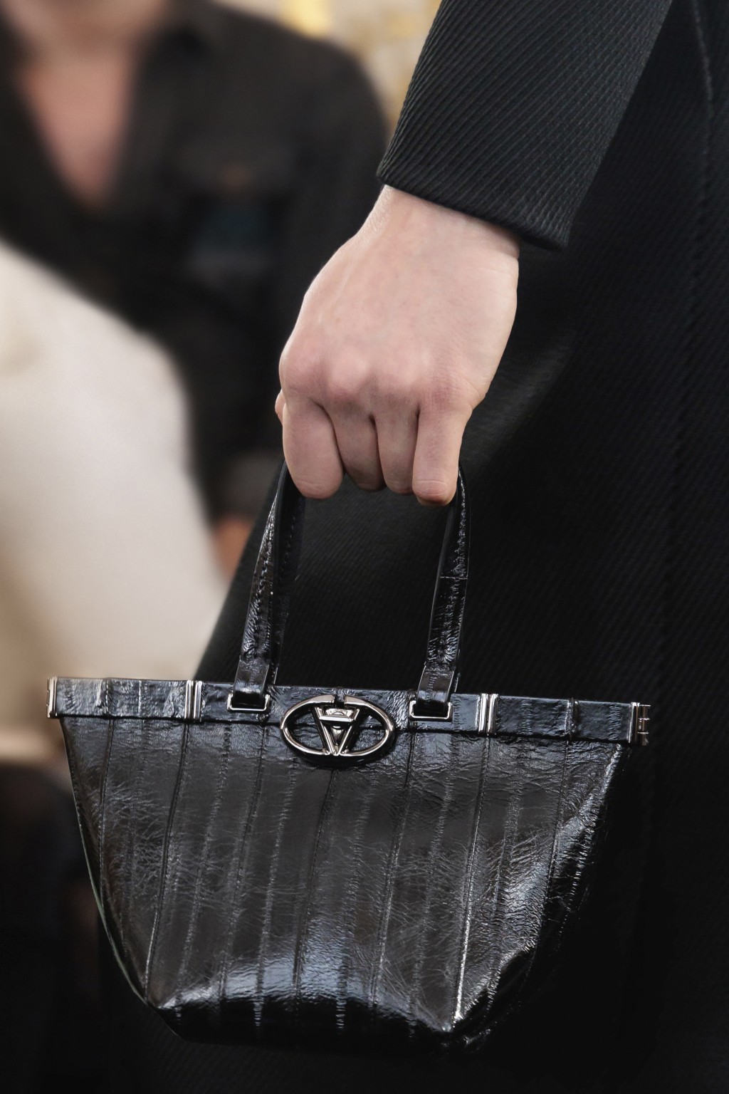 充满质感的皮革手挽袋，为黑色设计不至于单调。