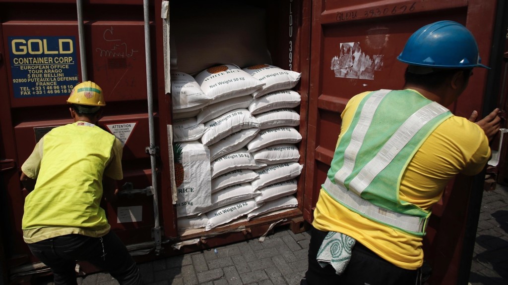 馬尼拉國際貨櫃碼頭的工人打開裝有進口大米的貨櫃。 路透社