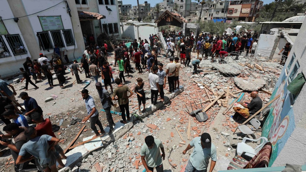 民众检查被炸学校的损毁情况。 路透社