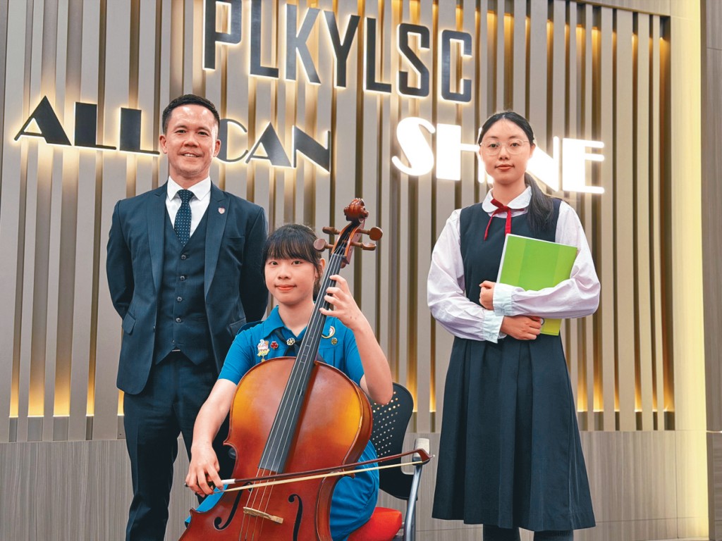 范林慧（中）與周芷慧（右）同獲校本資助參與課外活動及遊學團，校長溫家輝（左）強調校方會「應做盡做」，讓經濟因素不再成為學生成長的障礙。