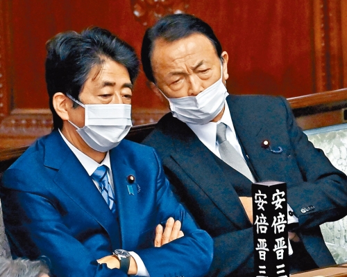 安倍晉三昨日在下議院全體會議上與自民黨副總裁麻生太郎交談。