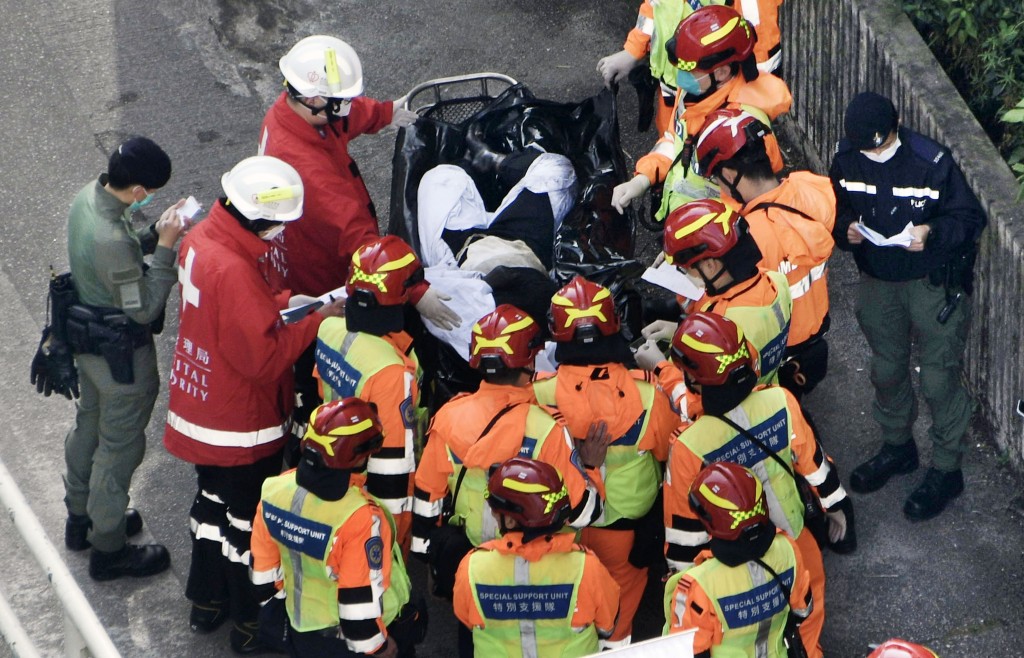 消防於起火大廈內抬出多具遺體。陳浩元攝