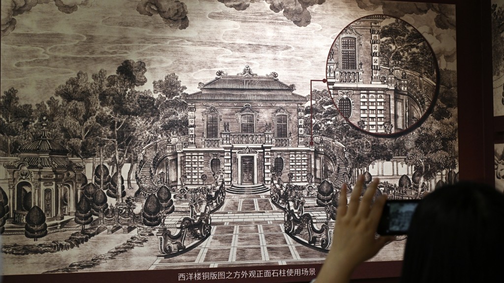參觀者在展覽上拍攝石柱使用場景圖。 新華社