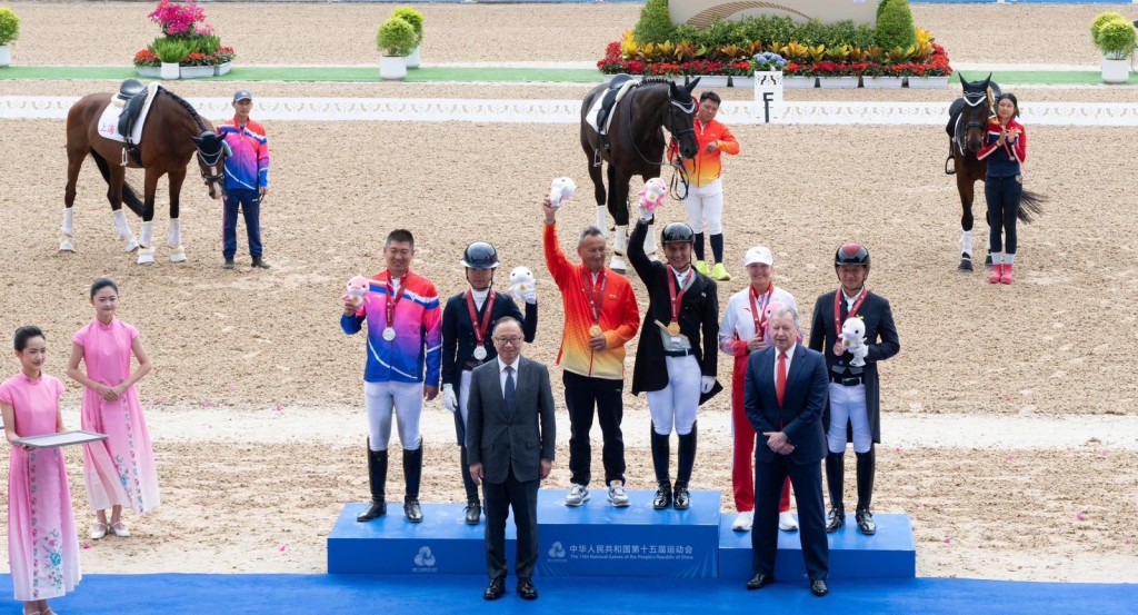 香港賽馬會主席廖長江（前排左）、行政總裁應家柏（前排右）向十五運會馬術賽事盛裝舞步個人賽的獲獎運動員頒發獎牌及紀念品。香港賽馬會圖片