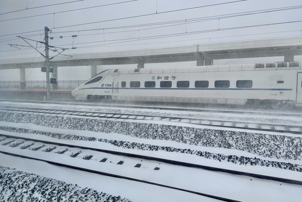 在黑龙江省方正县，一列列车在暴雪红色预警信号从方正站驶过。 新华社