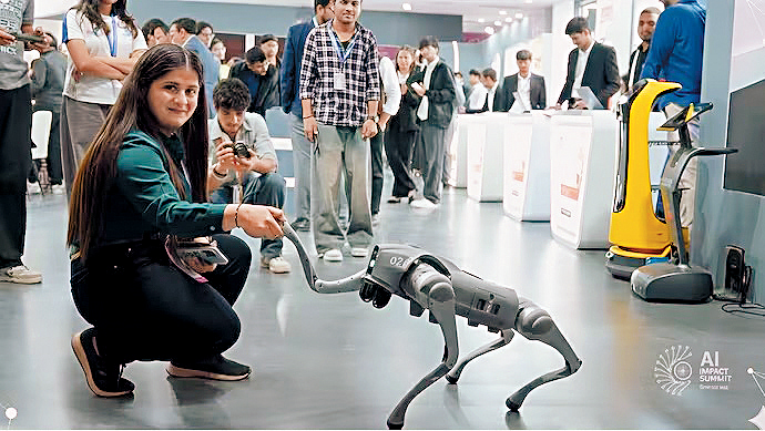 在新德里AI峰會場內的加爾戈蒂亞斯大學展位，有女子在逗弄實為中國製造的機械狗。