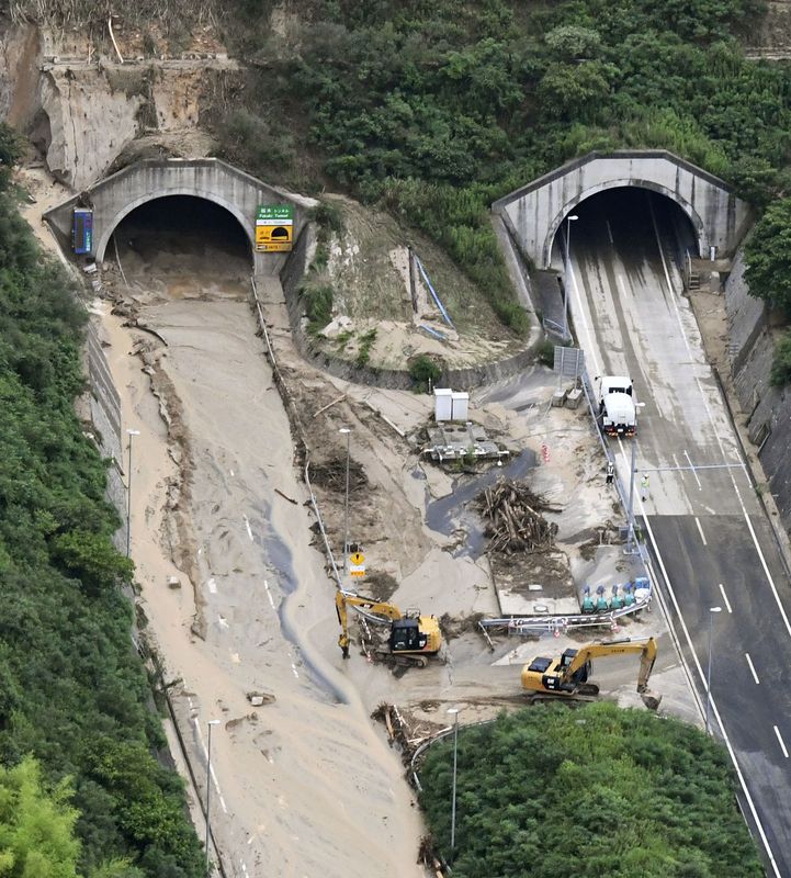 行車隧道堆滿山泥,工作人員忙於清理。AP