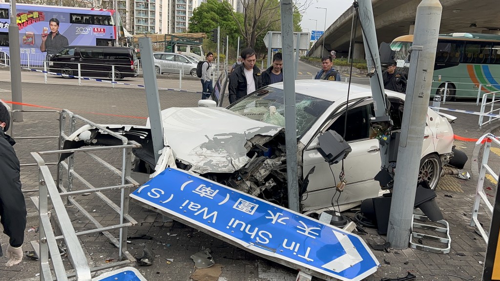 白色私家車衝上安全島撞欄及撞塌路牌。蔡楚輝攝