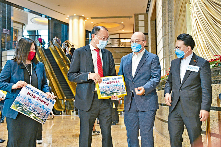 李家超的競選辦副主任陳勇（右一）和譚志源（右二）接收團體的建議書。