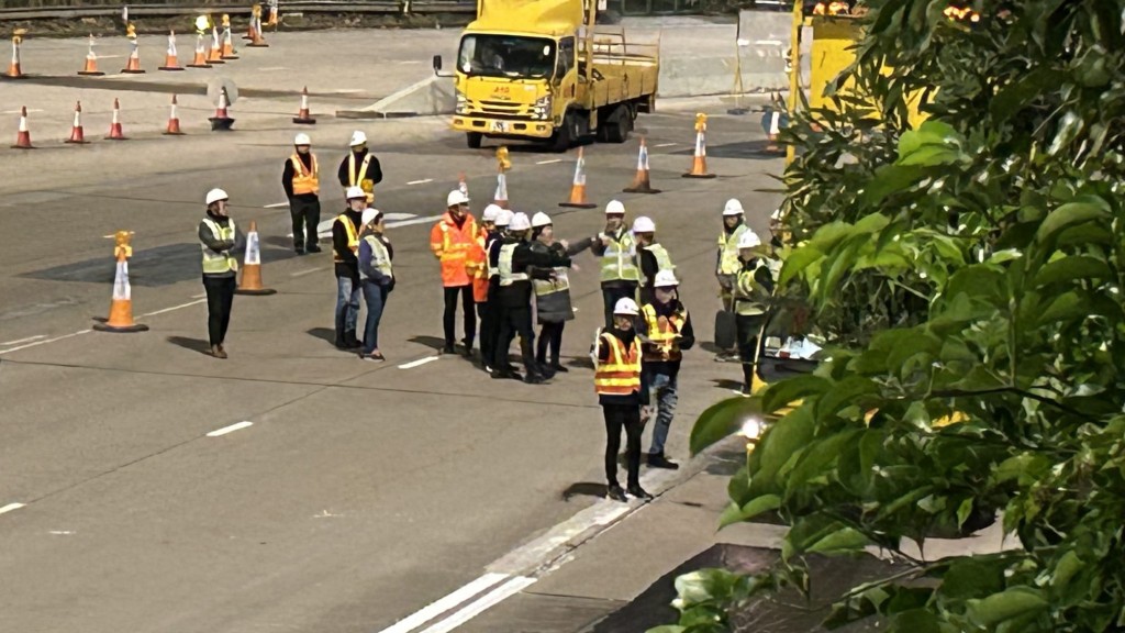 李頌恩站在行車線上近距離觀察準備情況，期間多次用手指比劃，似在落指示。