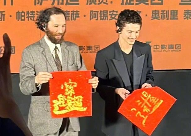 添麥菲與導演寫中文揮春。