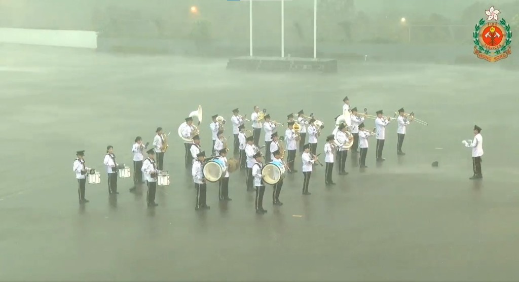 但入境處樂隊仍無懼風雨繼續演奏，更有隊員的帽子被狂風吹走。（消防處FB影片截圖）