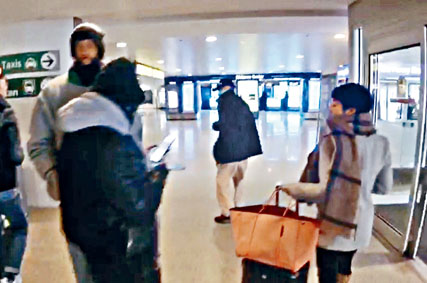 ■ 季炳雄(中)步出機場大堂,有一男一女接機。