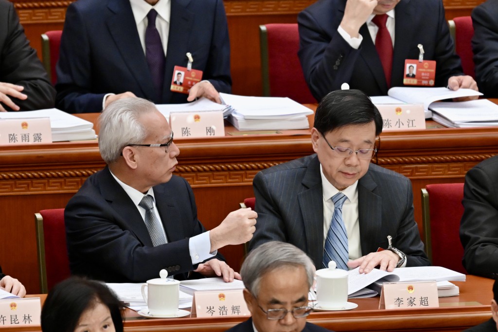 二人皆認真聆聽政府工作報告，期間岑浩輝一度「出手」指點。