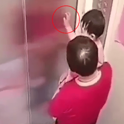見到小童一直以手觸碰電梯門為樂