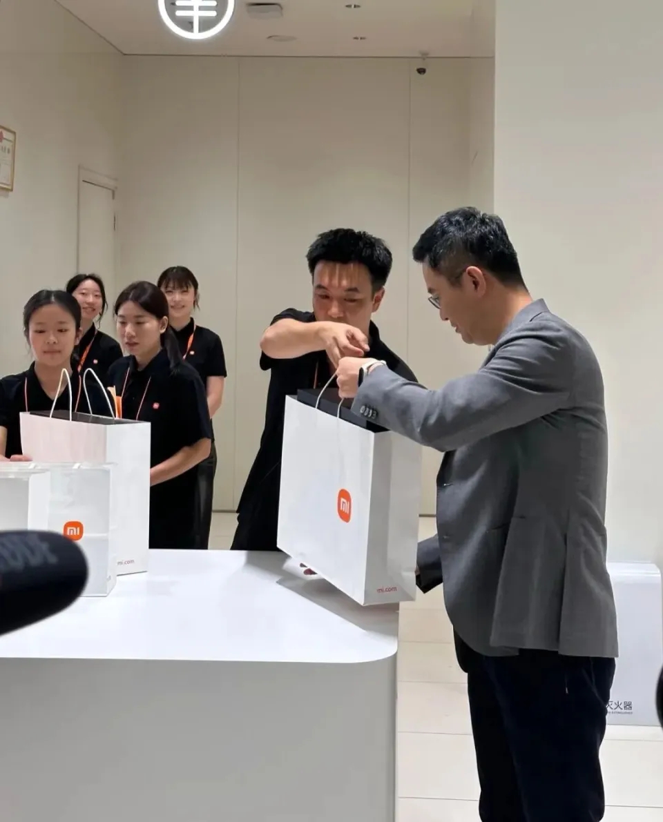 盧偉冰親自給客戶交付手機。