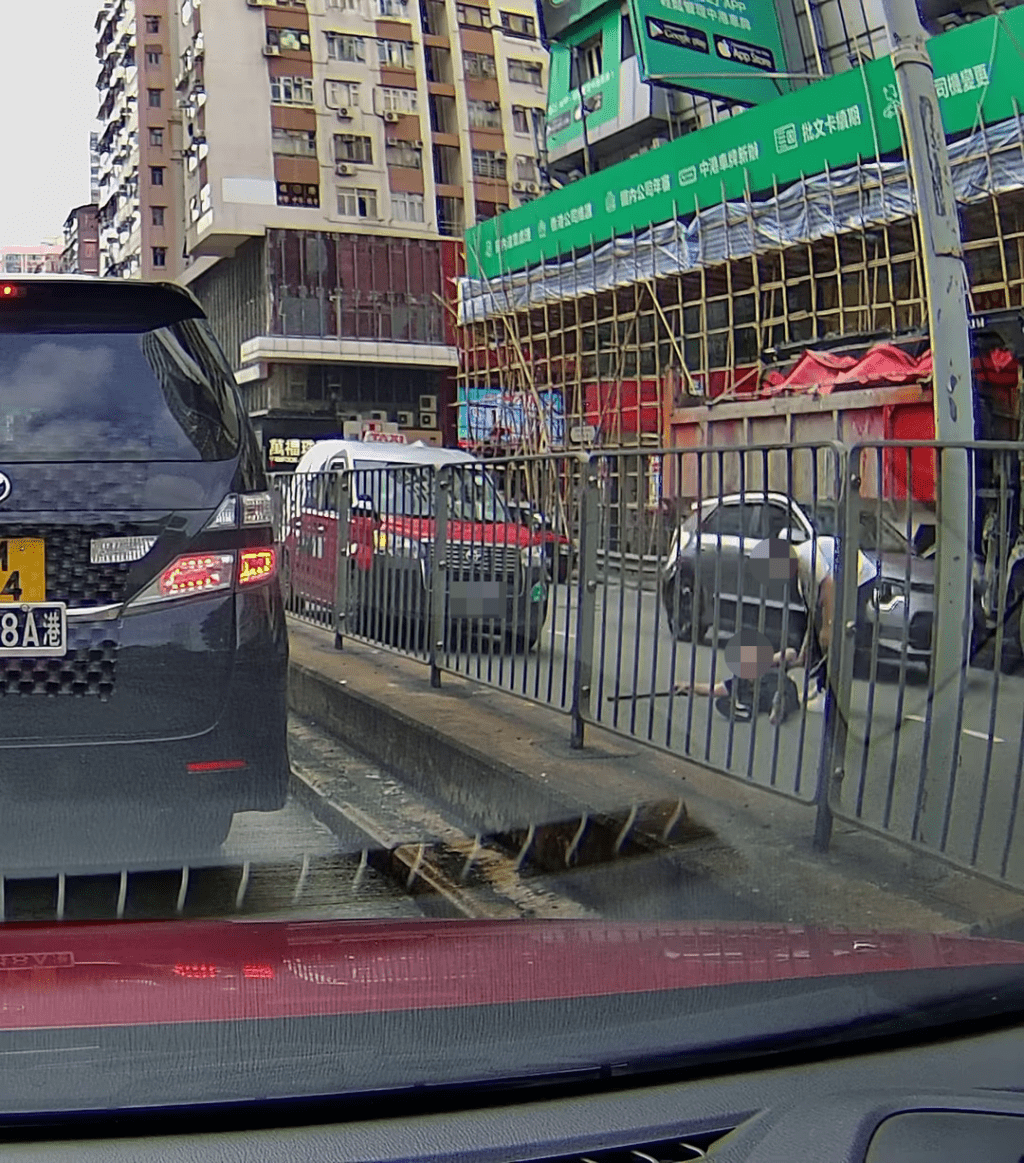 白衫男試圖拉起黑衫男，惟黑衫男堅持倒地不起。車cam L（香港群組）