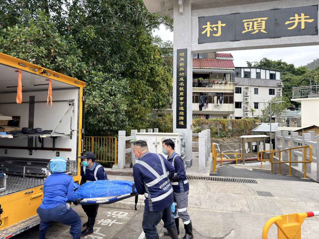 仵工將死者遺體抬上車，移送往殮房。梁國峰攝