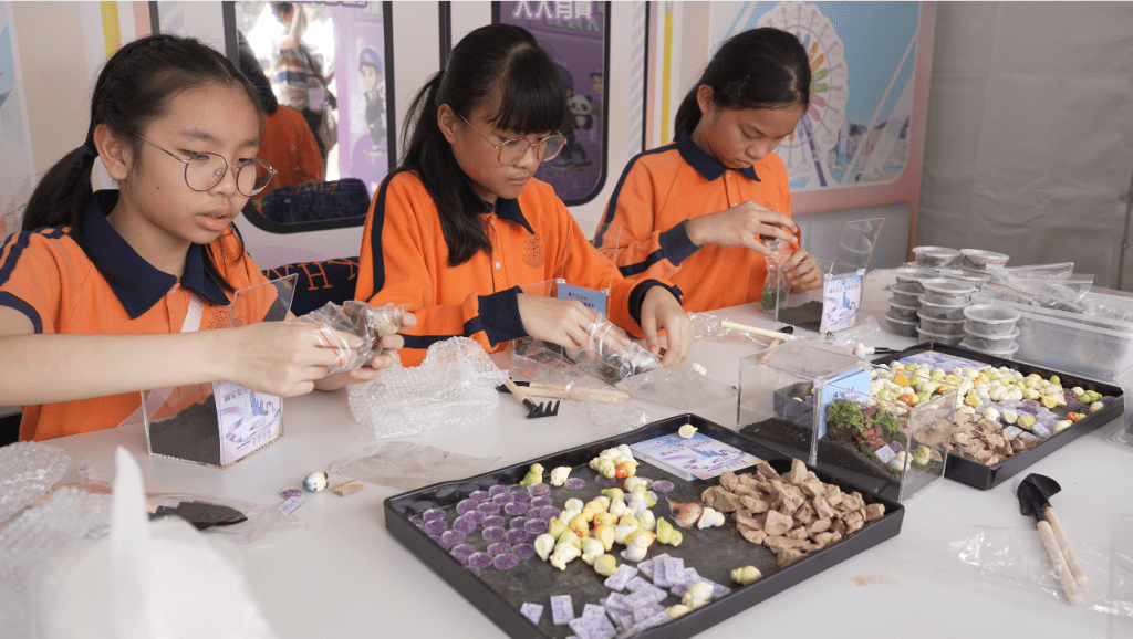 小學生在國安處花卉展攤位內學習製作生態箱。