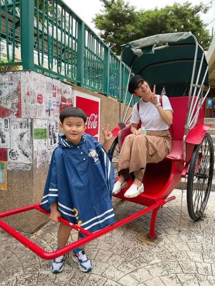 在主題公園中兩母子玩得投入。