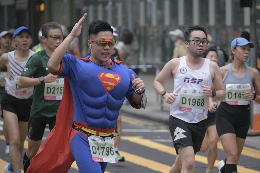 早上在旺角滙丰大厦附近，有大批跑手路经。有跑手一身超人装扮。（陈浩元摄）