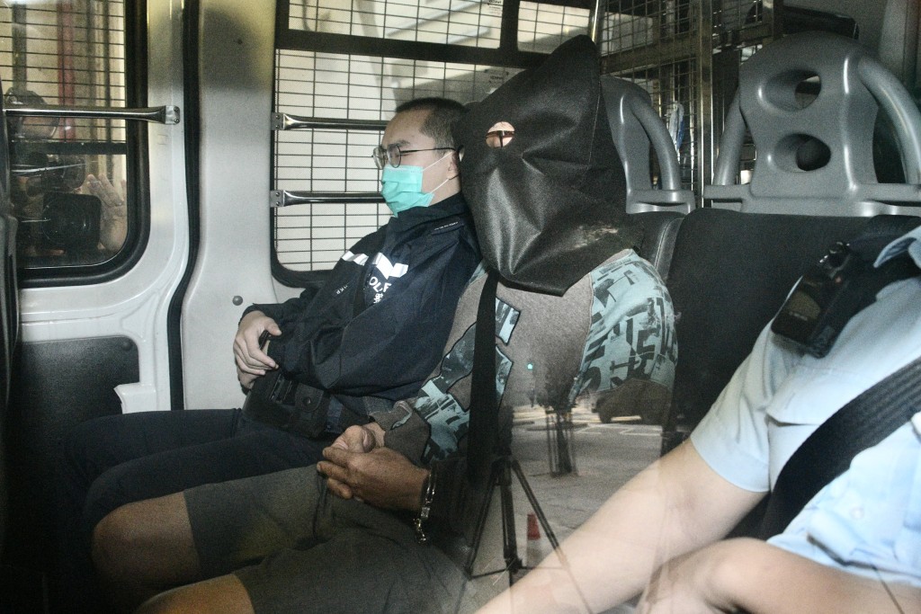 被告今身穿褐色上衣及戴黑框眼鏡，被警員押至東區裁判法院提堂。陳浩元攝