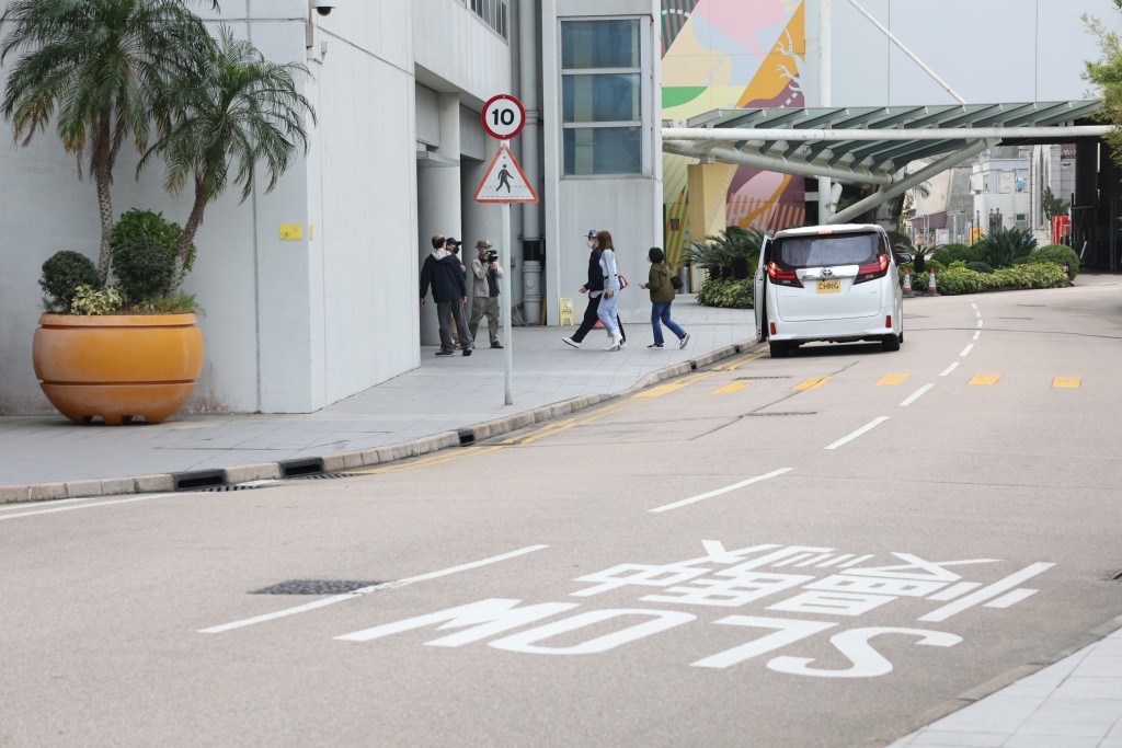 隨後下車的楊明戴上了CAP帽，隨二人步入大樓。