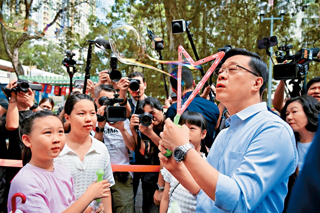 李家超主動與屋邨遊樂場玩耍的小朋友交流，又跟他們一起玩吹肥皂泡。