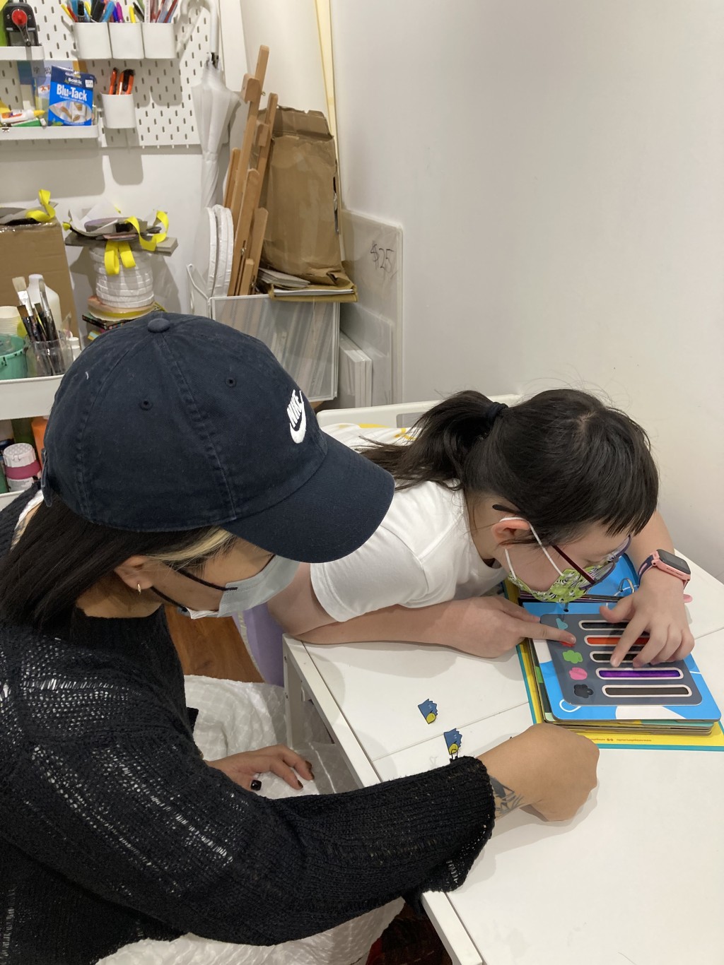 何卓樂(左)為基層家庭講解如何應用《情緒急救包》。 何卓樂(左)為基層家庭講解如何應用《情緒急救包》。