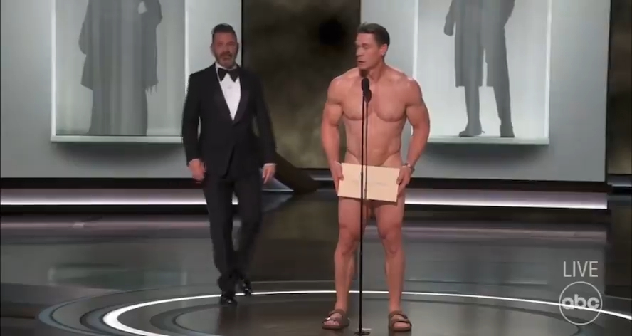 庄先拿（John Cena）一开始躲在布帘后装作害羞不敢出场，主持人Jimmy Kimmel鼓励他勇敢走出来。  ​