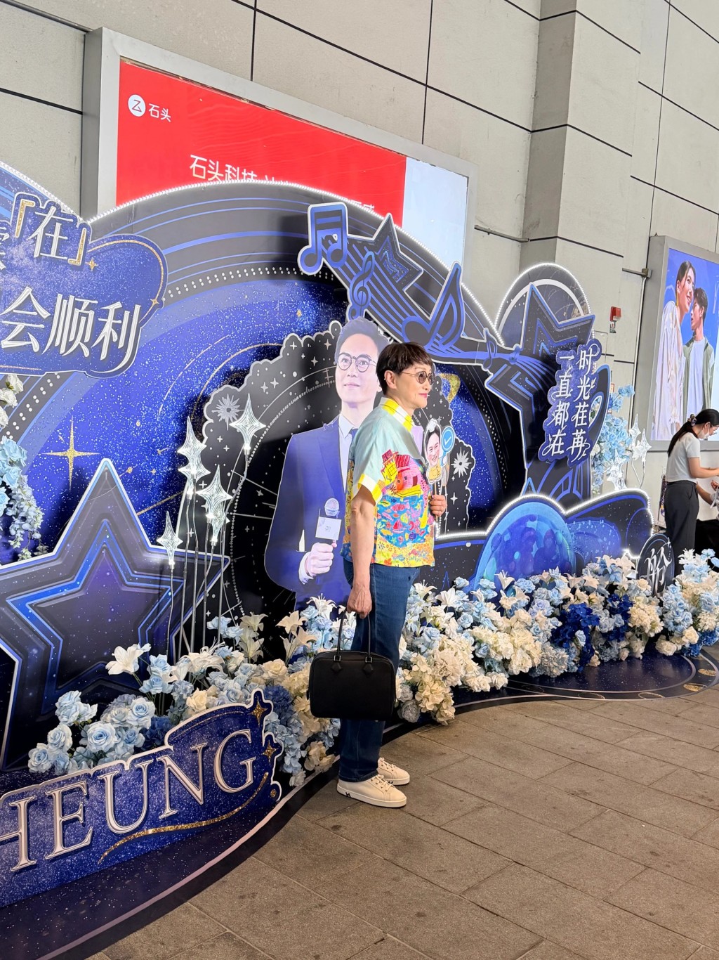 張智霖媽媽入場前在佈景板前打卡。 張智霖媽媽入場前在佈景板前打卡。