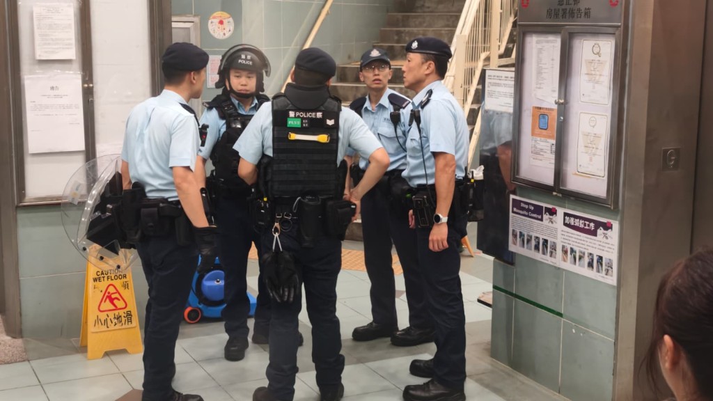 多名衝鋒隊人員到慈正邨正暉樓追尋涉事女子下落。黃文威攝 多名衝鋒隊人員到慈正邨正暉樓追尋涉事女子下落。黃文威攝
